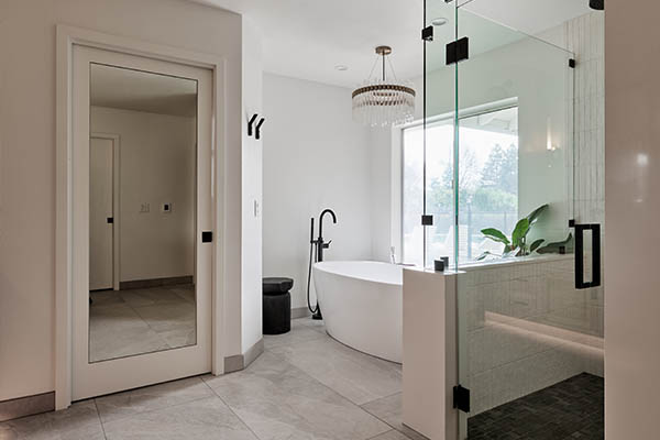 remodeled white bathroom with glass shower and white bathtub