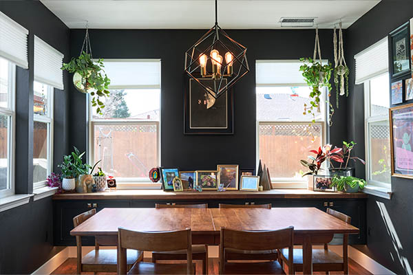 black dining room with plants and a wooden table